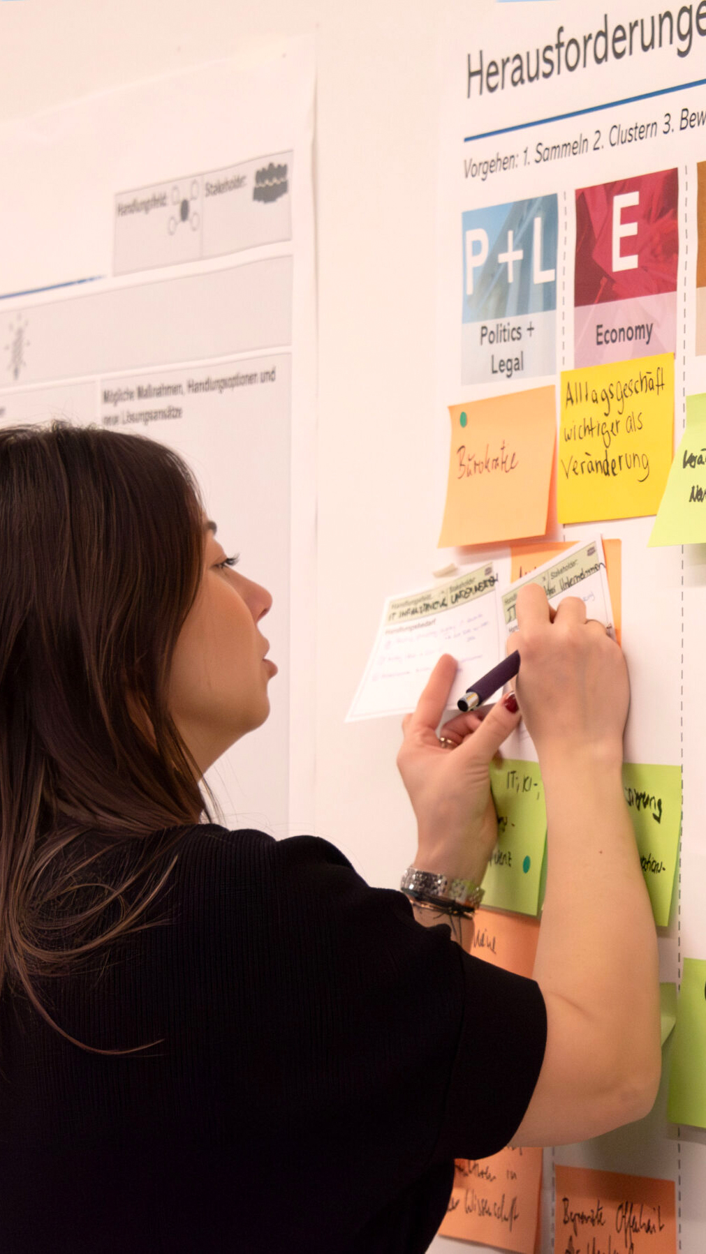 Workshopteilnehmerin arbeitet am Ergebnisposter.