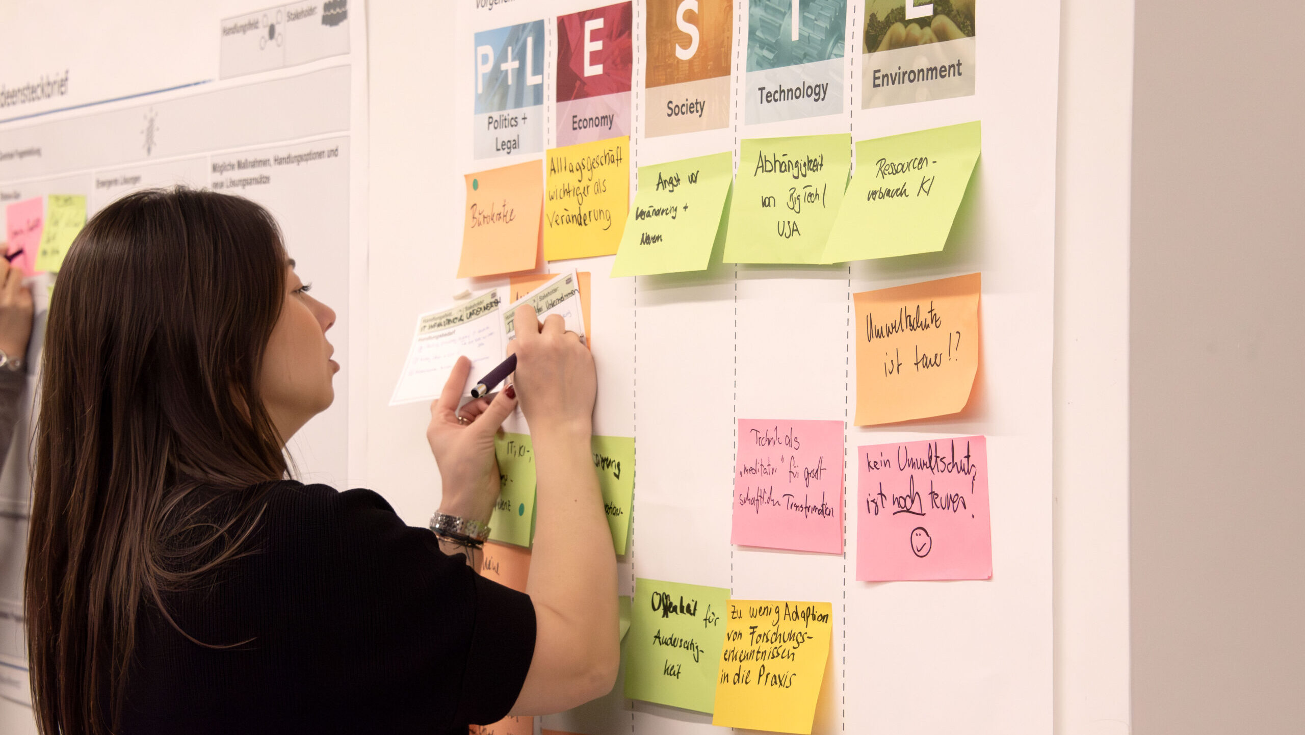 Workshopteilnehmerin arbeitet am Ergebnisposter.