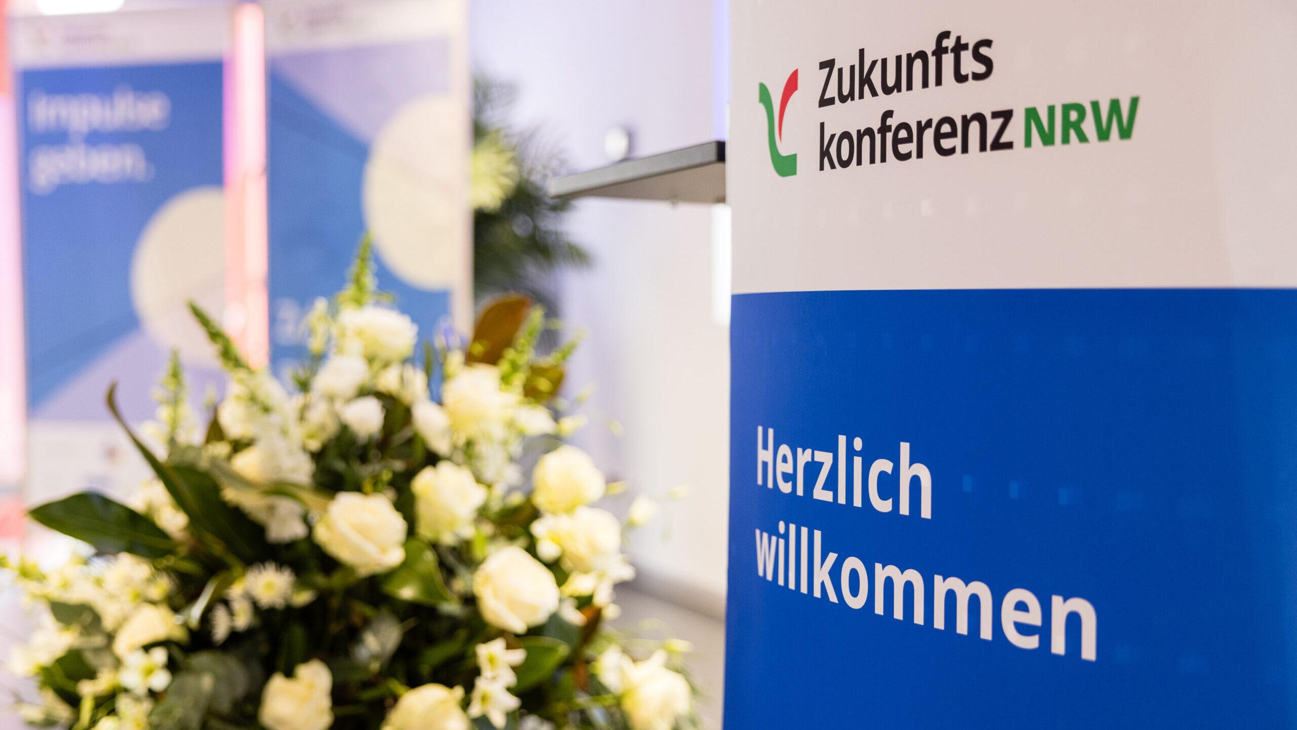 Plakat der Zukunftskonferenz mit Blumenbouquet. 
