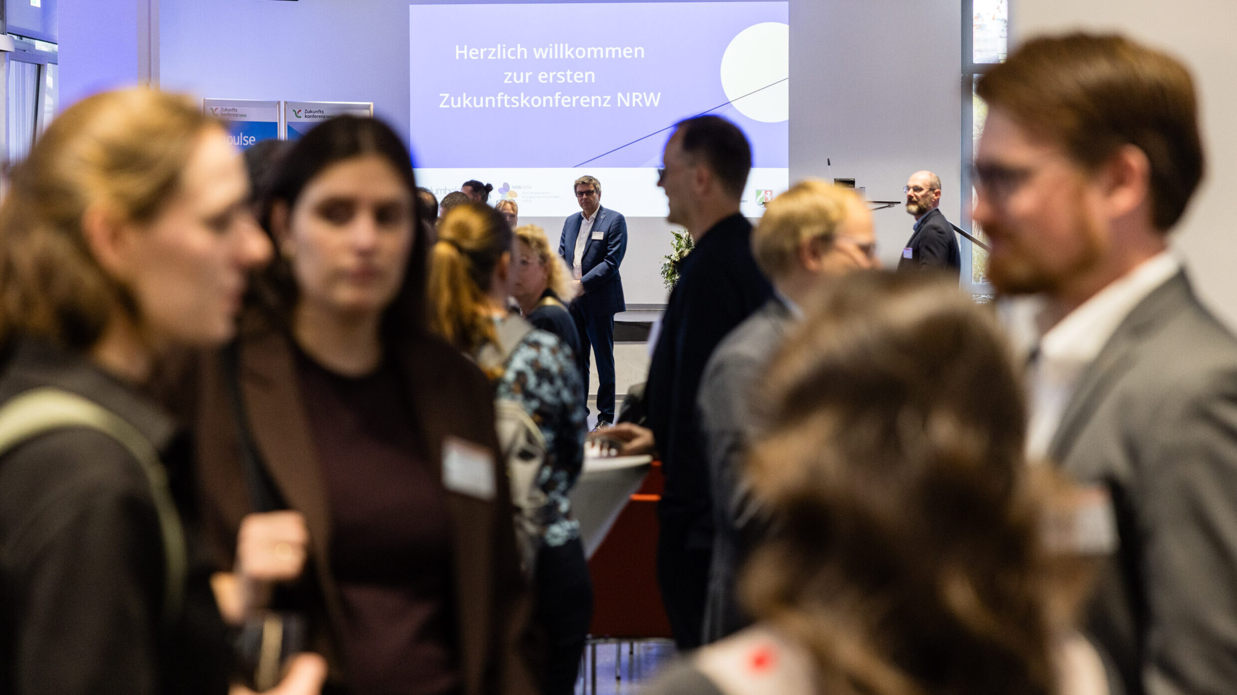 Teilnehmende der Eröffnungsfeier tauschen sich aus. 