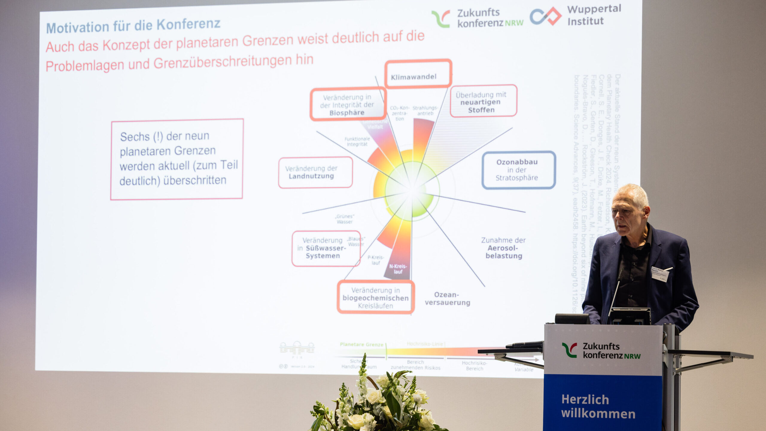 Redner hält Präsentation auf der Bühne.