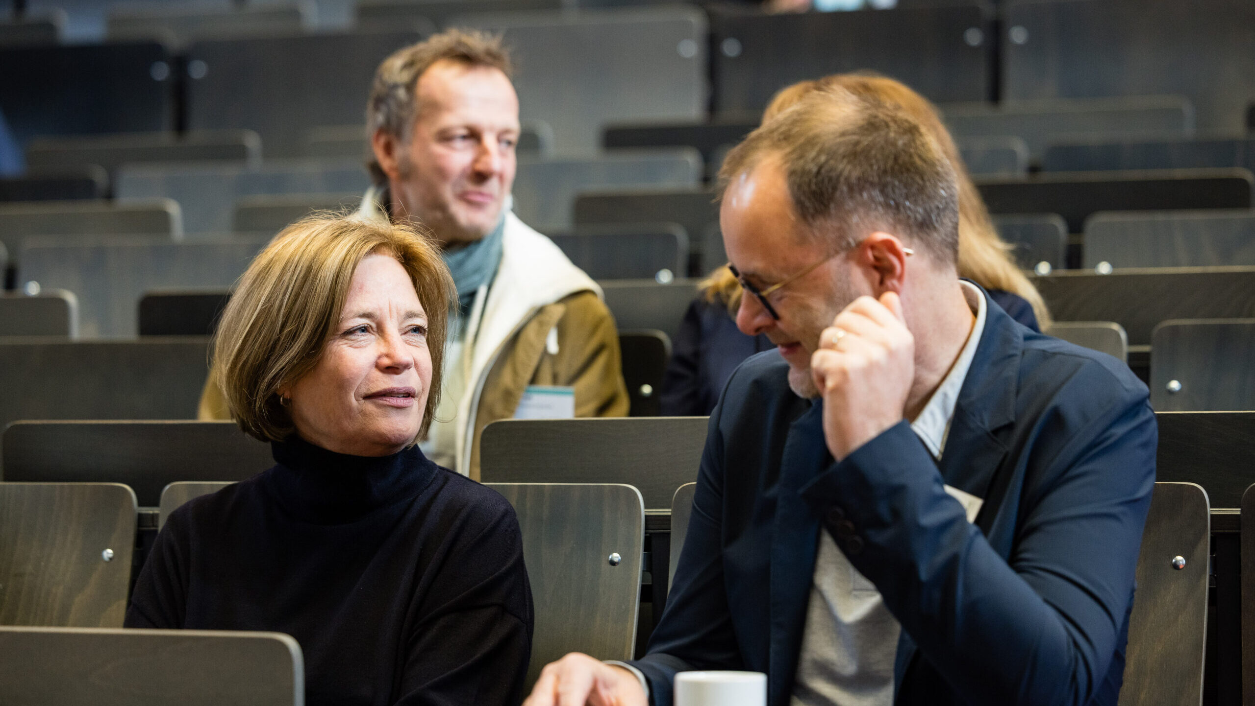 Menschen im Hörsaal und unterhalten sich.