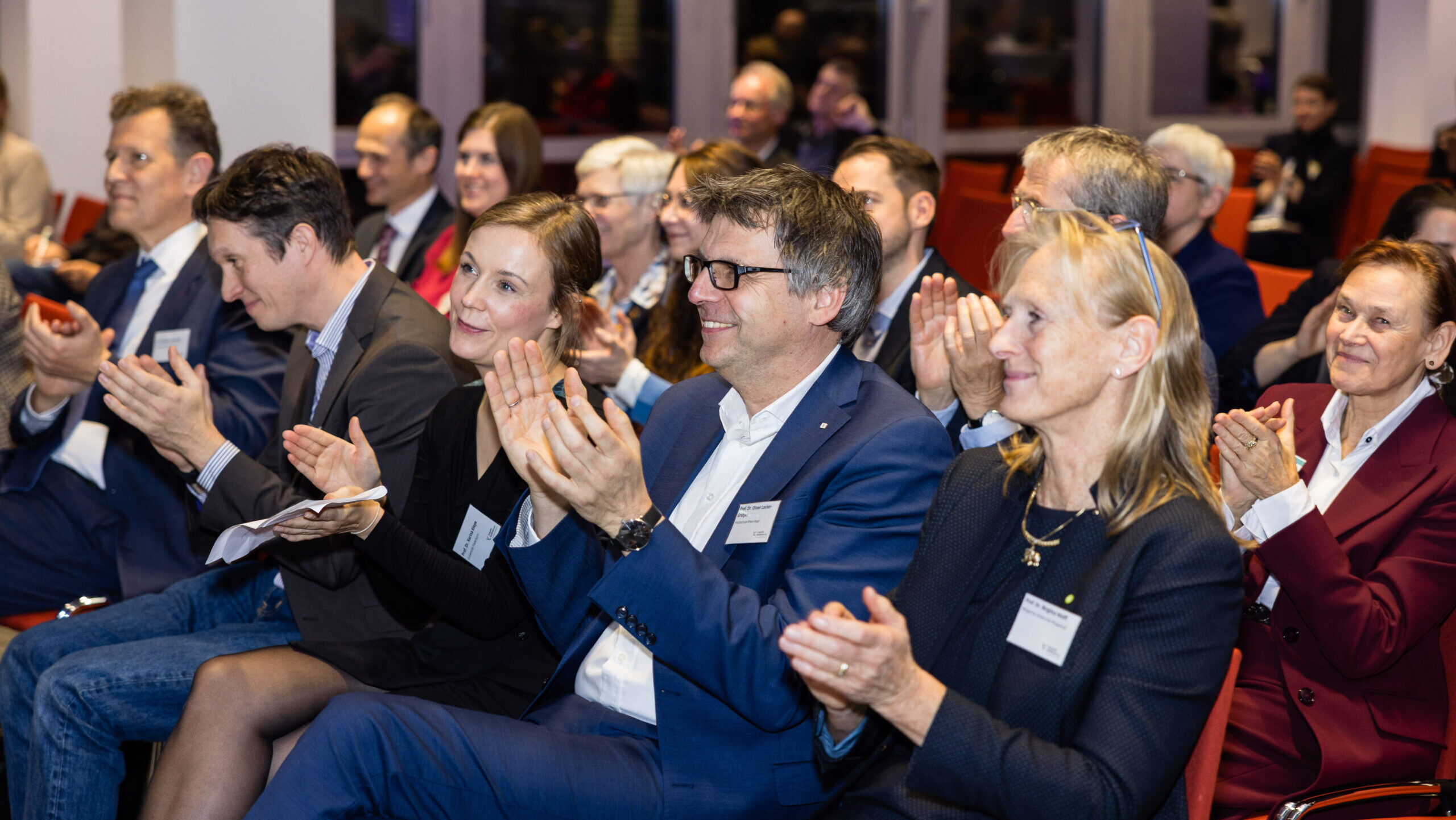 Menschen im Publikum applaudieren.